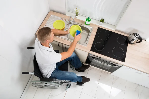 Инвалид с мытьем посуды — стоковое фото