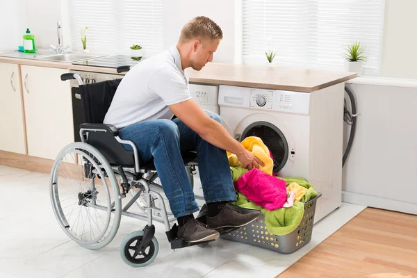 Hombre discapacitado poniendo toallas — Foto de Stock