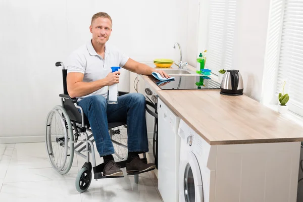 Man op rolstoel schoonmaken kachel — Stockfoto