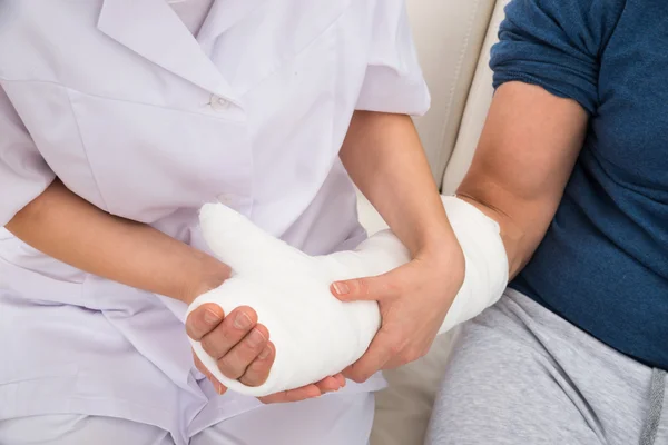 Doctor sosteniendo la mano fracturada — Foto de Stock