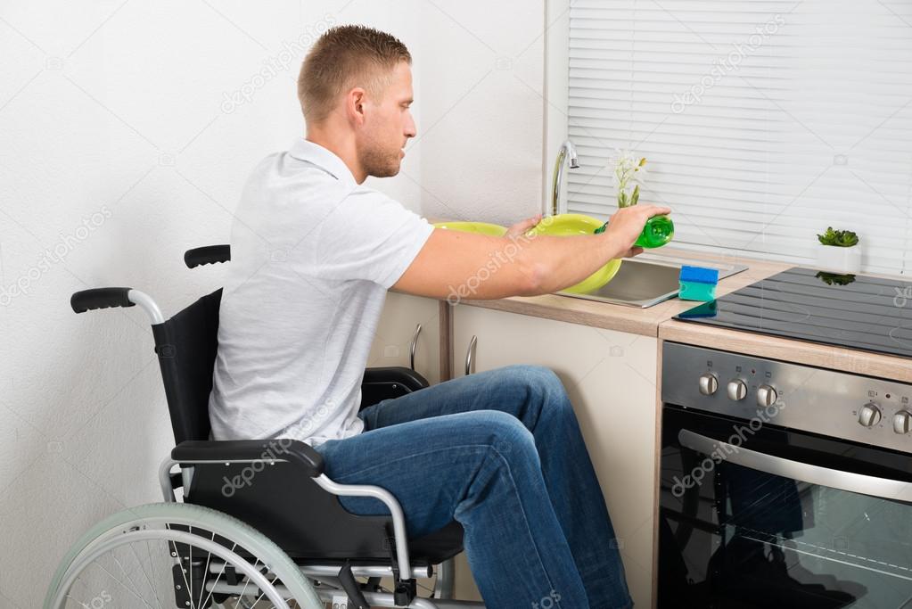 Man On Wheelchair Washing Dishes