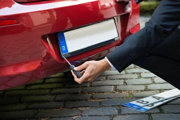 Man Placing New Plate on Car — Stock Photo, Image