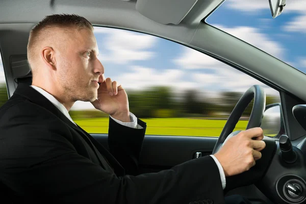 Homem usando celular durante a condução — Fotografia de Stock