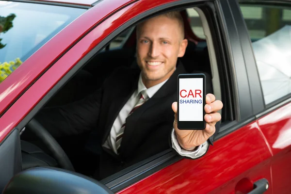 Uomo d'affari Mostrando cellulare in auto — Foto Stock