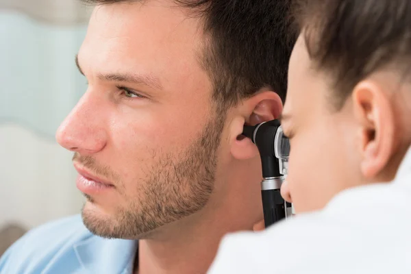 Arzt schaut ins Ohr des Patienten — Stockfoto