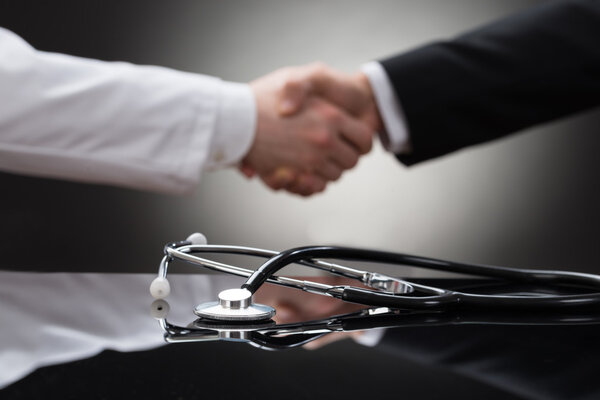 Doctor And Businessman Shaking Hands