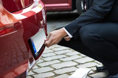 Man Holding Number Plate