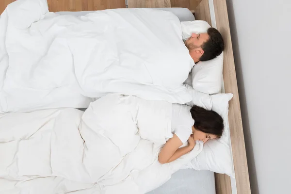 Пара спящих на кровати — стоковое фото