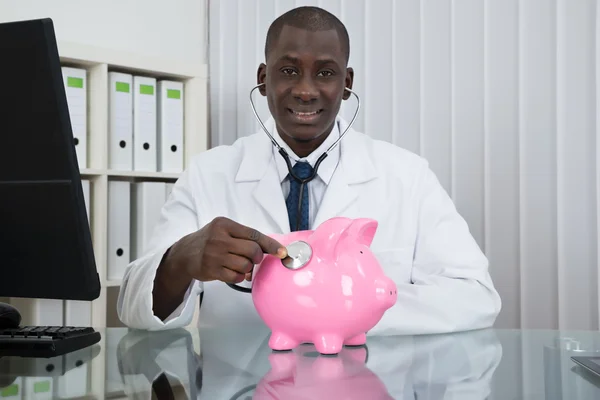 Médico examinando Piggybank — Foto de Stock