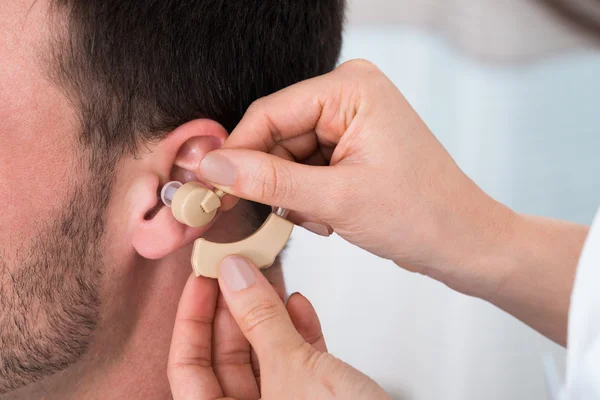 Hands Inserting Hearing Aid — Stock Photo, Image