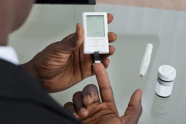 Patiënt handen met Glucometer — Stockfoto