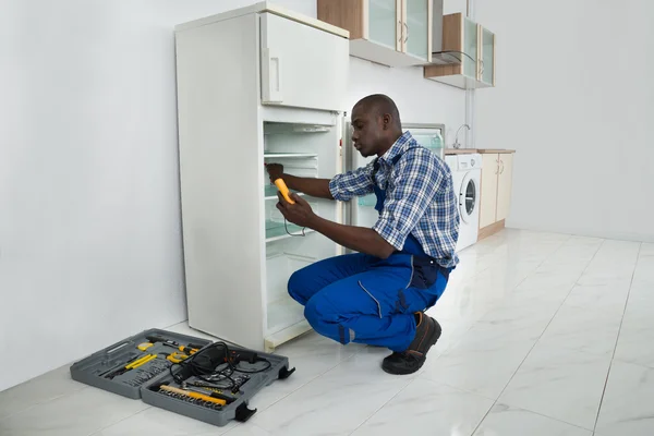 Reparador reparando geladeira — Fotografia de Stock