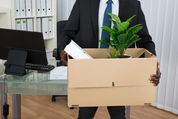 Empresário segurando caixa de papelão — Fotografia de Stock