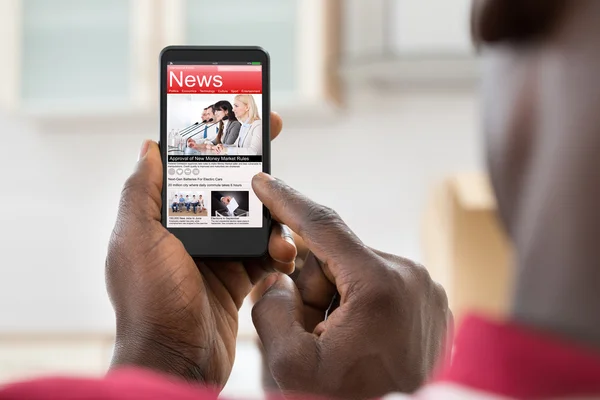 Afrikansk man läsa nyheter — Stockfoto