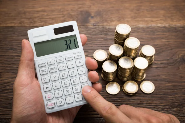 Homem de negócios calculando moedas — Fotografia de Stock