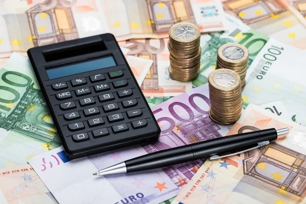 Taschenrechner und Stift auf Euro-Banknoten — Stockfoto