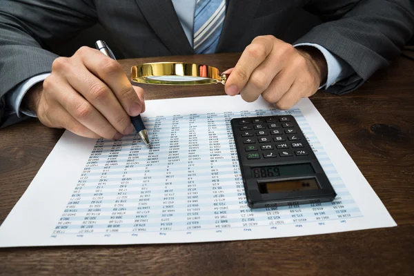 Empresário que inspeciona dados financeiros — Fotografia de Stock