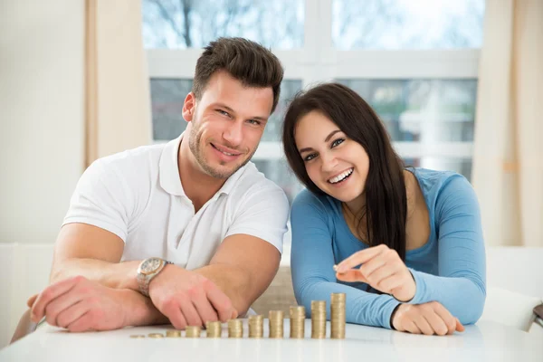 Couple arrangeant des piles de pièces — Photo