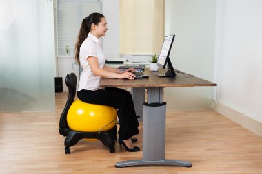İş kadını Fitness topu üzerinde oturan