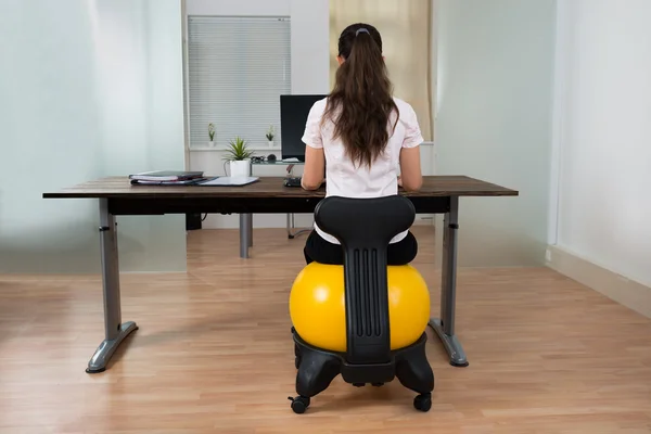 Mujer de negocios sentada en la pelota de fitness — Foto de Stock