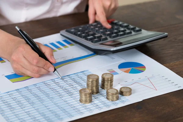 Empresario con monedas sobre gráfico — Foto de Stock