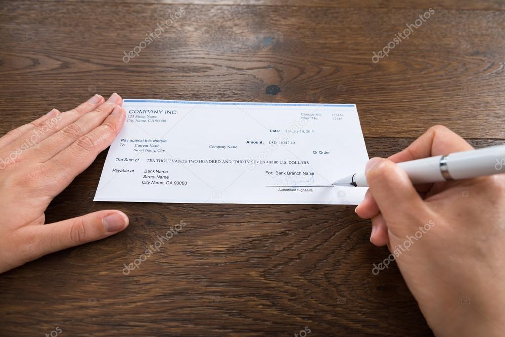Hands Signing Cheque
