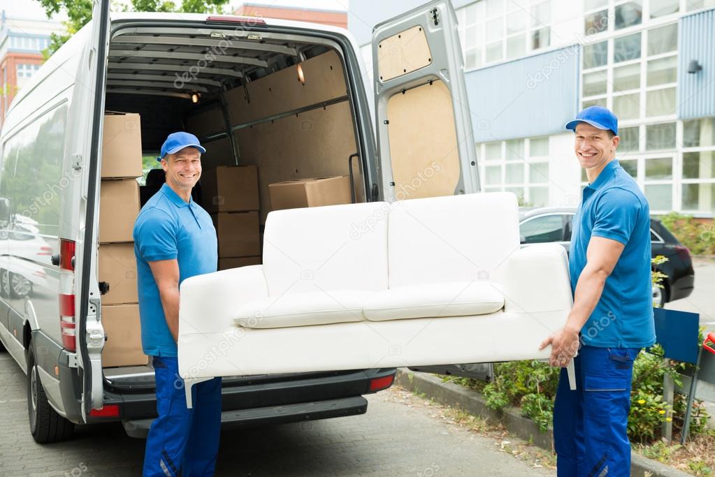 Workers Adjusting Sofa In Truck