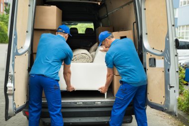 Workers Adjusting Sofa In Truck clipart