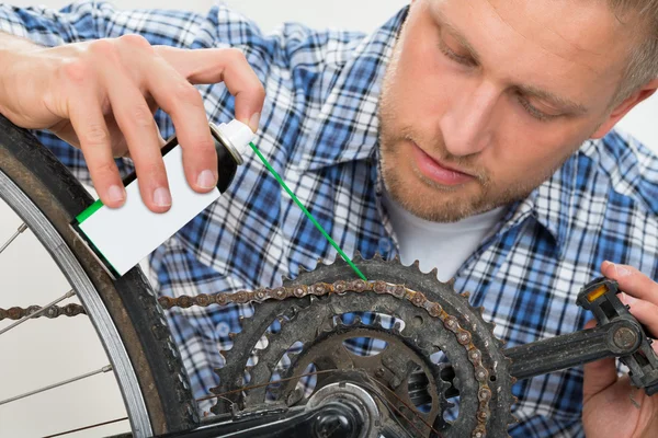 Hombre engrasando bicicleta cadena — Foto de Stock