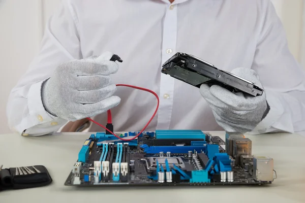 Técnico con placa base y disco duro — Foto de Stock