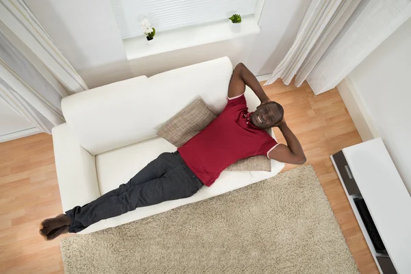 Hombre joven relajándose en el sofá —  Fotos de Stock