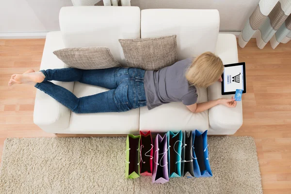 Donna sdraiata con tablet digitale — Foto Stock