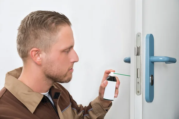 Male Carpenter Lubricating Door — Stock Photo, Image