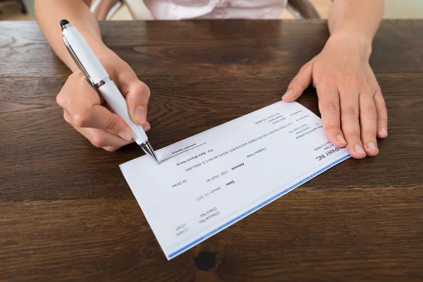 Mãos de pessoa assinando Cheque com caneta — Fotografia de Stock