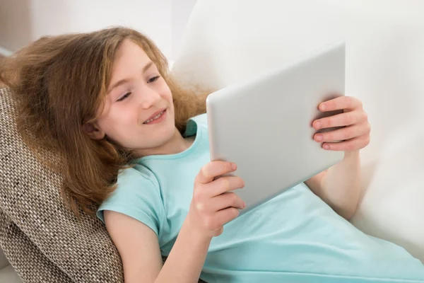 Дівчина на дивані з цифровим планшетом — стокове фото
