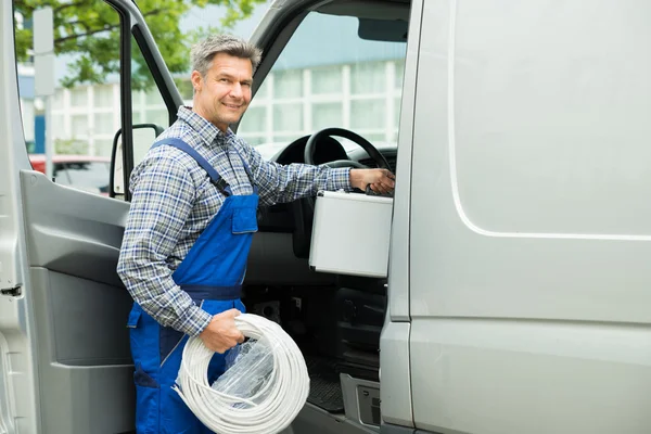 Arbeiter mit Werkzeugkiste und Kabel in Transporter eingestiegen — Stockfoto