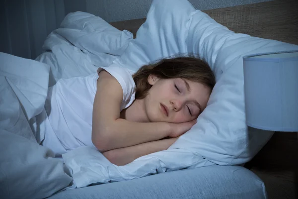 Chica durmiendo en la cama — Foto de Stock