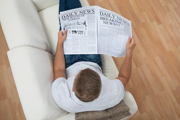 Ο άνθρωπος διαβάζει εφημερίδα στο σπίτι — Φωτογραφία Αρχείου