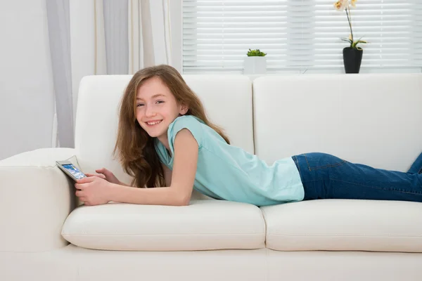 Menina com tablet digital na sala de estar — Fotografia de Stock