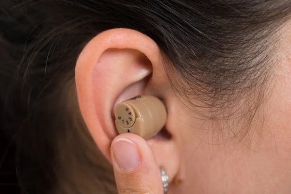 Orelha de mulher com aparelho auditivo — Fotografia de Stock