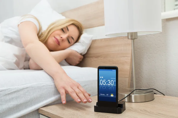 Kobieta Snoozing Alarm na ekranie telefonu komórkowego — Zdjęcie stockowe