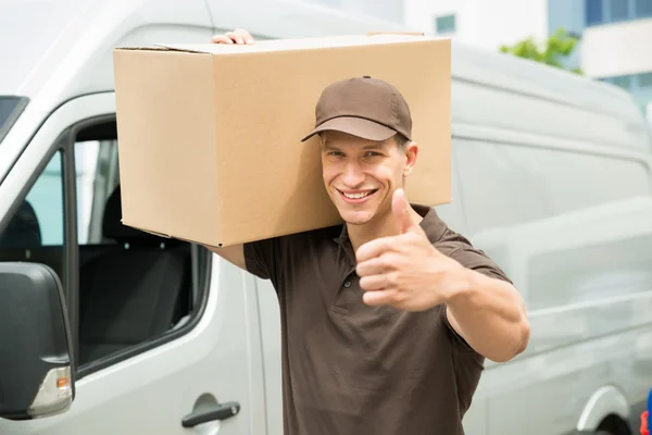 Entrega hombre con cajas de cartón mostrando pulgares hacia arriba signo — Foto de Stock