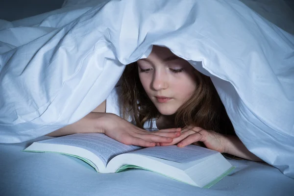 Ragazza lettura libro in camera da letto — Foto Stock