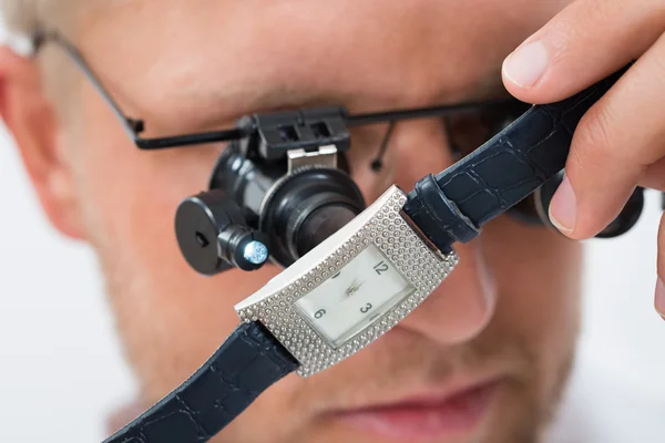 Homem olhando relógio de pulso com loupe — Fotografia de Stock