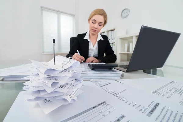 Zakenvrouw berekening factuur aan balie — Stockfoto