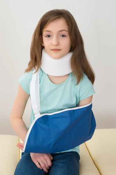 Девушка с брекетом на шее и повязкой на руке — стоковое фото
