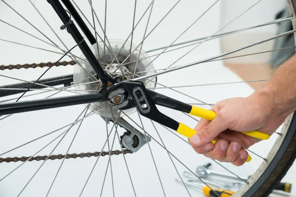 Manos de persona Fijación de la rueda de bicicleta Imagen De Stock