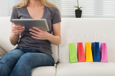 Dijital Tablet ve alışveriş torbaları kadın ile