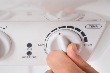 Person Turning The Knob Of Electric Boiler clipart