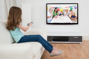 Kız televizyon önünde uzaktan kumanda ile